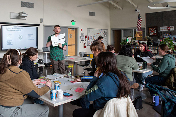Elliot Drake-Maurer (standing) leads the workshop attendees through an activity at the "Wayfinding: Exploring Jobs, Employability, and Career Education in the Outdoors" workshop in Junction City.