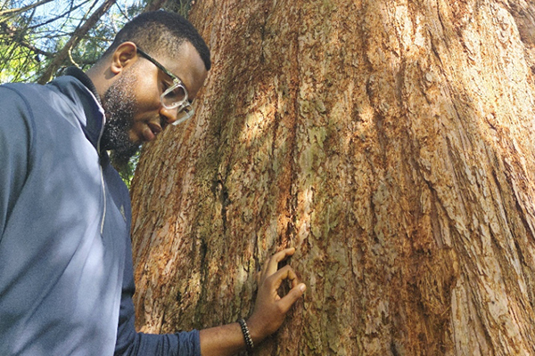 Chukwuemeka Valentine Okolo stands by a big tree