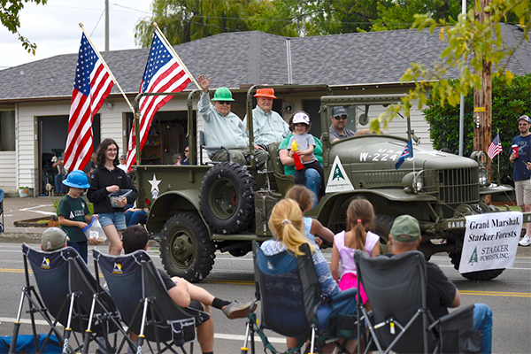 Bond Starker and Gary Blanchard of Starker Forests ride in the grand marshal's vehicle, a World War II era truck similar to one that was once used on the family's property. (Photo by Andy Cripe/Philomath News)