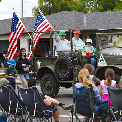 Bond Starker and Gary Blanchard of Starker Forests ride in the grand marshal's vehicle, a World War II era truck similar to one that was once used on the family's property. (Photo by Andy Cripe/Philomath News)