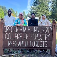 Afifa Zahid (second from left) with three other 2025 Branching Borders interns posed in front of OSU Research Forests sign