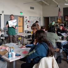 Elliot Drake-Maurer (standing) leads the workshop attendees through an activity at the "Wayfinding: Exploring Jobs, Employability, and Career Education in the Outdoors" workshop in Junction City.
